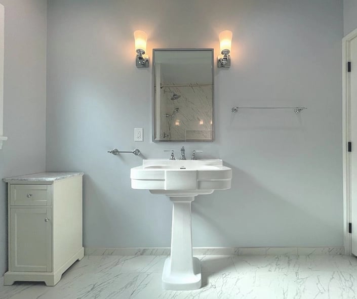 A clean bathroom remodel look with a classic pedestal sink 