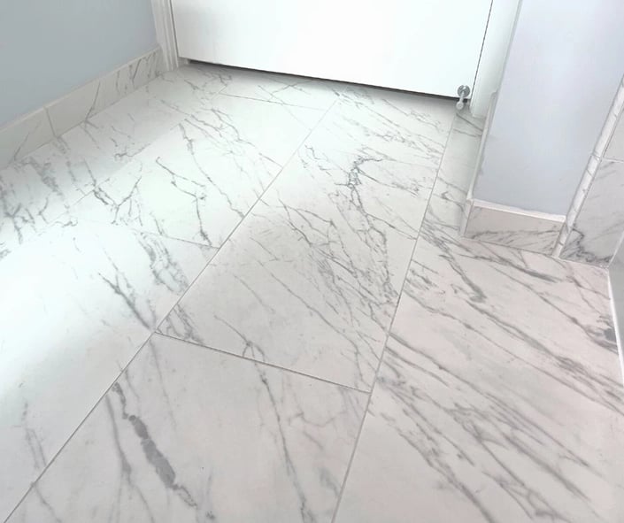 The tile installed during this bathroom renovation is a porcelain material made to look identical to marble. 