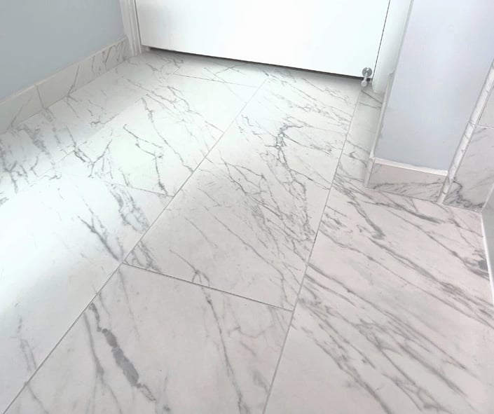 The tile installed during this bathroom renovation is a porcelain material made to look identical to marble. 