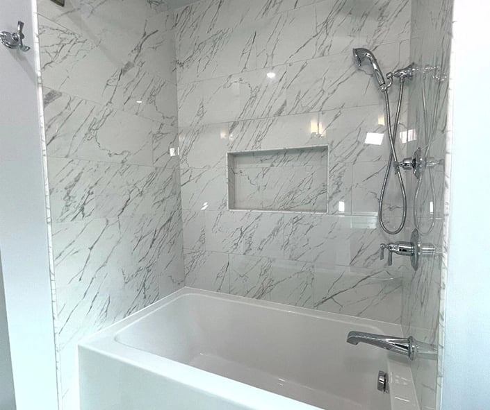 Brizo chrome hand wand and shower fixtures used for the soaker tub in this bathroom remodel.