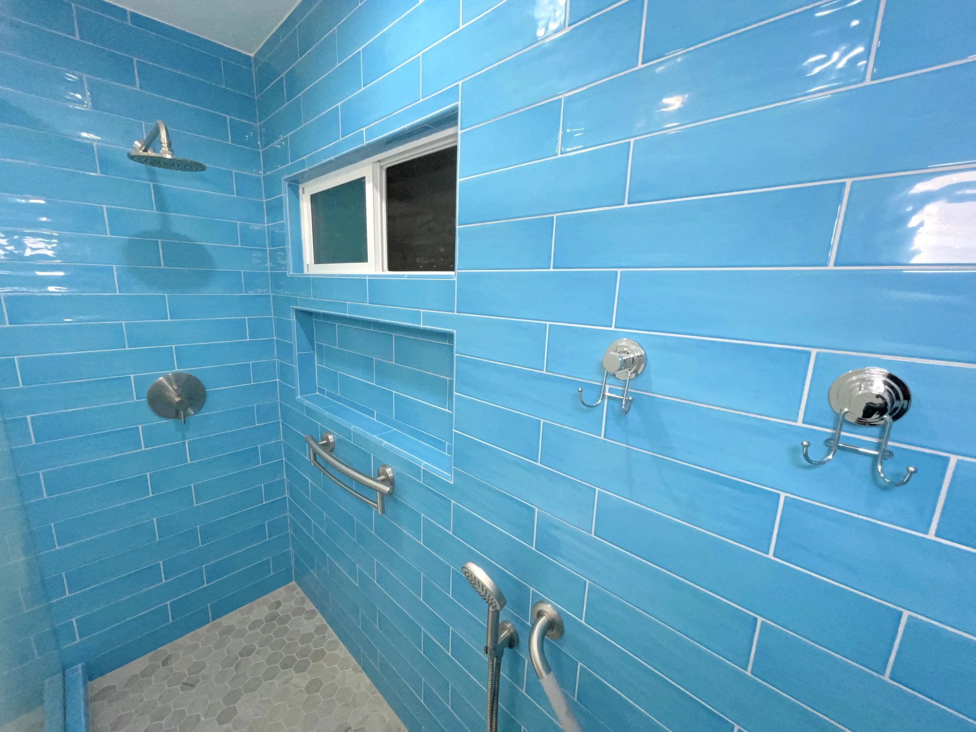 Chrome fixtures and blue glass tile was used floor to ceiling for the shower in the master bathroom.