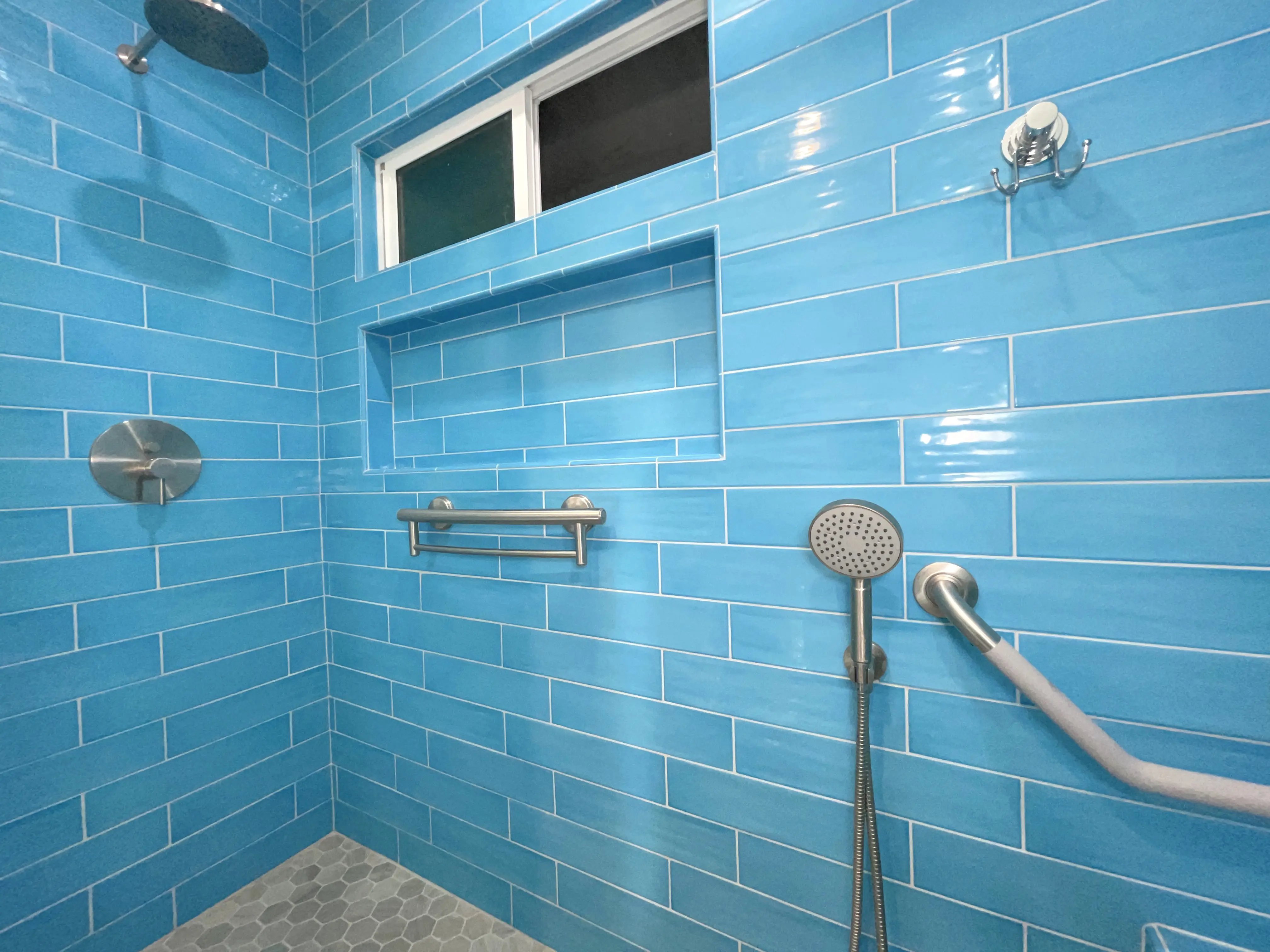Blue glass tile was installed floor to ceiling in the shower for the primary bathroom.