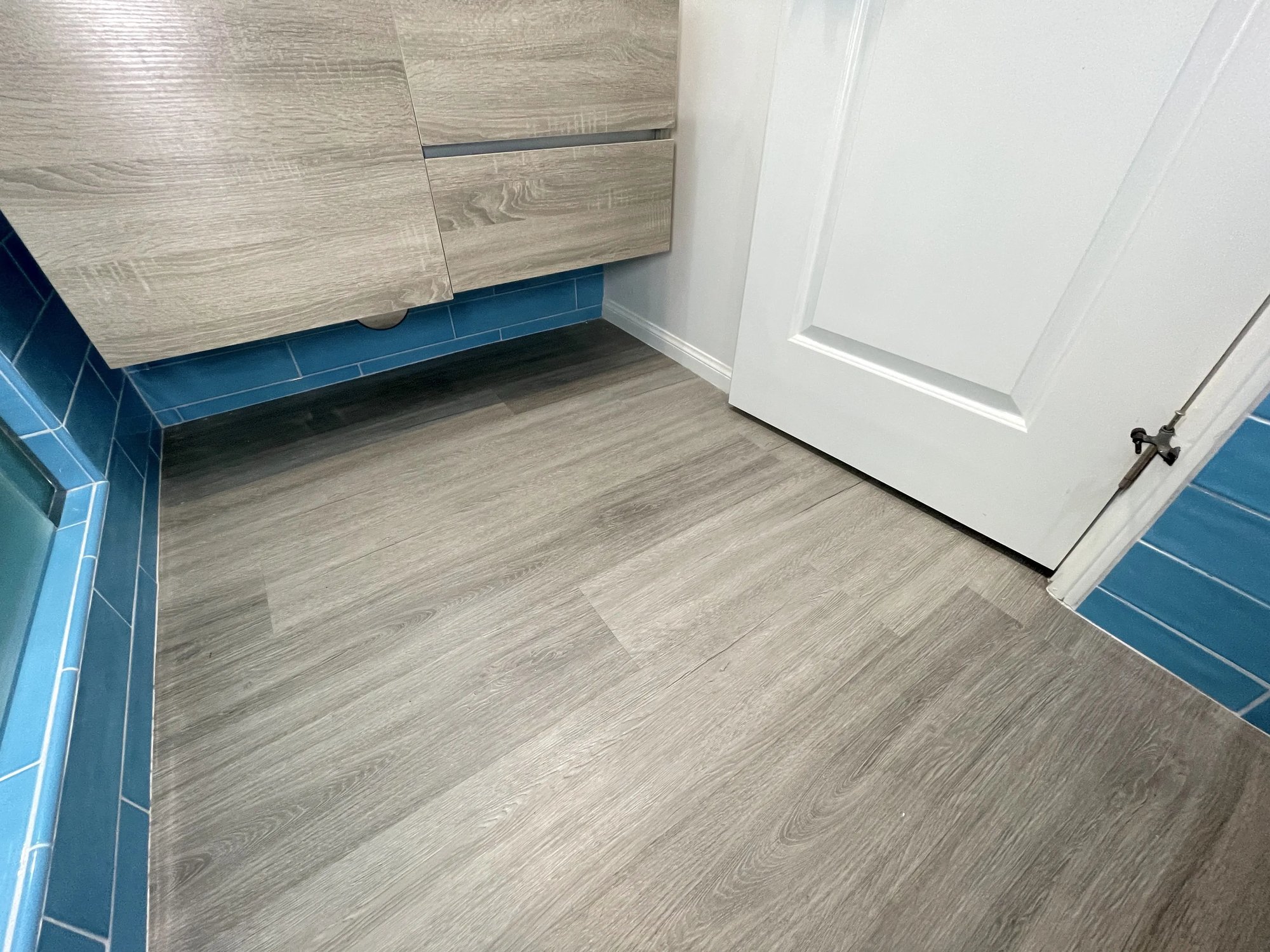 Porcelain floor tile that looks like wood was used for the master bathroom remodel to match the color tone and texture of the vanity.